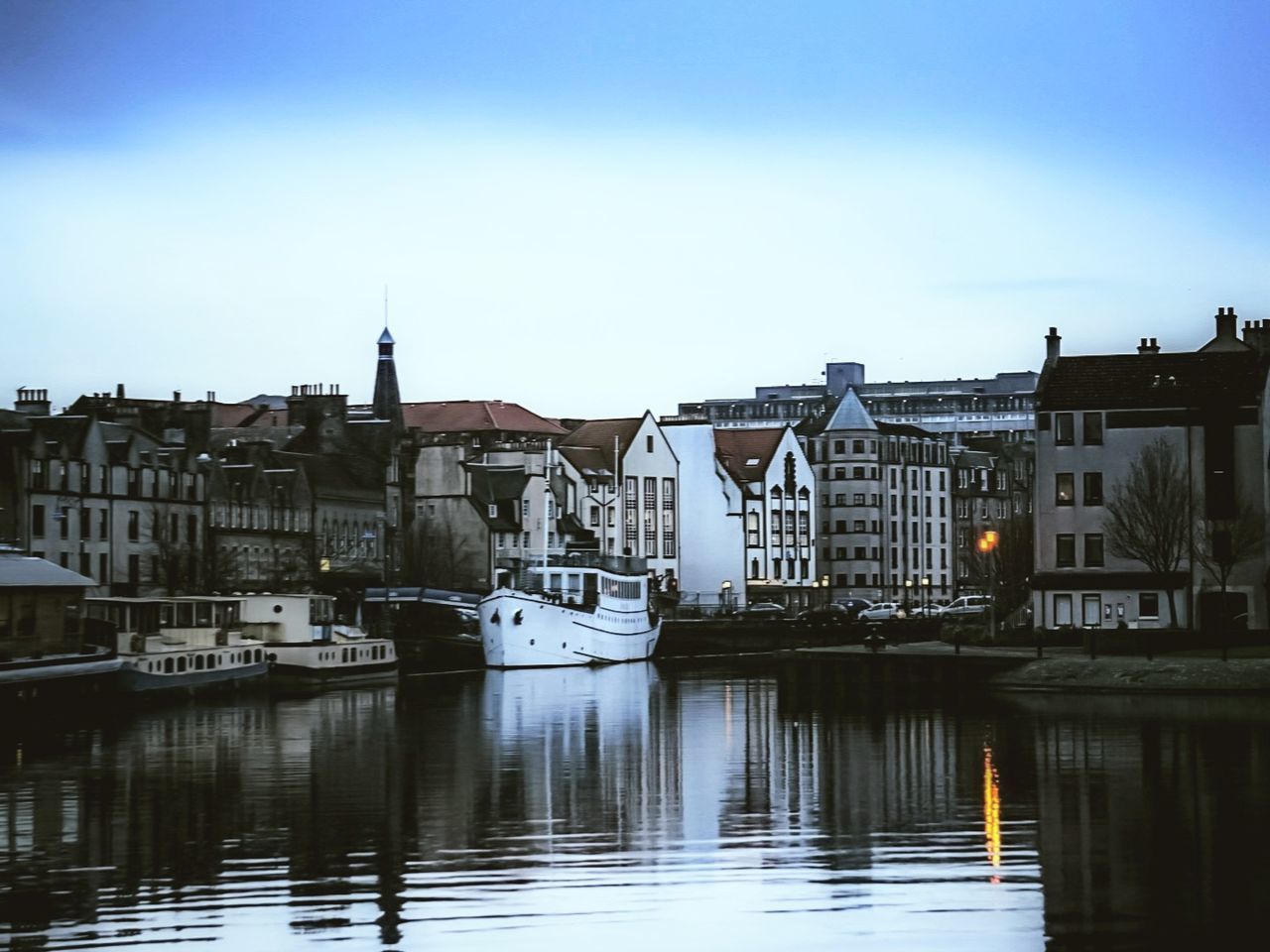 water, architecture, building exterior, built structure, building, transportation, nautical vessel, mode of transportation, sky, waterfront, reflection, city, residential district, no people, moored, nature, river, harbor, day, outdoors, sailboat, yacht, row house, passenger craft, luxury, port