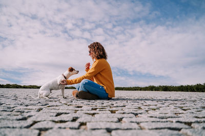 Smiling woman with floor against sky