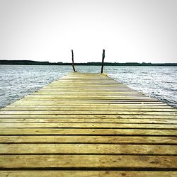 Pier over sea against clear sky