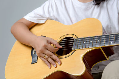 Midsection of woman playing guitar