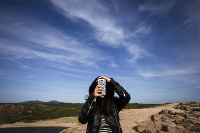 Full length of woman standing on landscape against sky