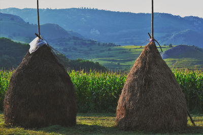 Hay bales on field against sky