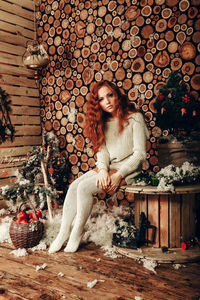 Portrait of woman sitting on floor in snow