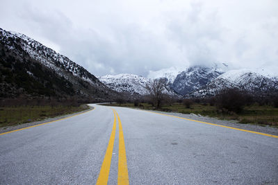 Road by mountain against sky