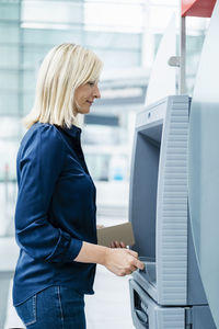 Mature businesswoman using atm machine