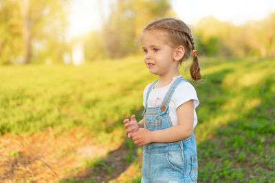 Cute girl looking away while standing in park