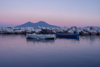 Boats are docked in naples port, in backgroud is standing out vesuvius 