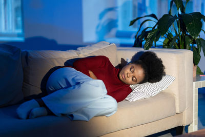 Exhausted african woman resting on sofa at home, anxious black female feeling lonely in empty house