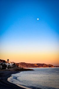 Scenic view of sea against clear sky at night