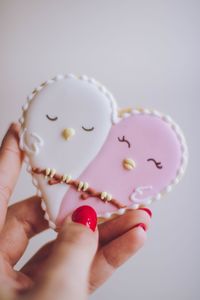 Cropped hand holding heart shape against white background