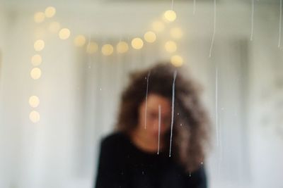 Portrait of woman photographing through window