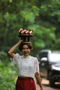 Portrait of a smiling young woman holding plant