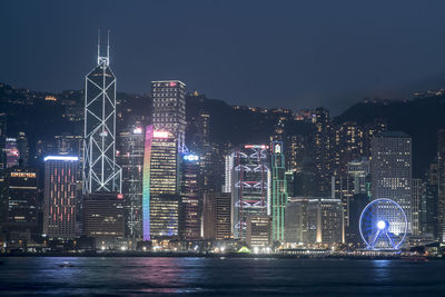 Illuminated cityscape against clear sky at night