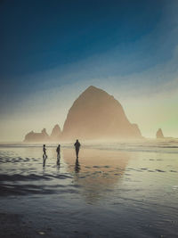 People on beach against sky