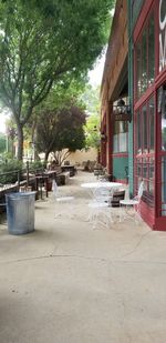 Empty chairs and tables on street by building