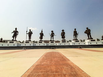 Statues over landscape against clear blue sky