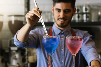 Midsection of bartender making drink