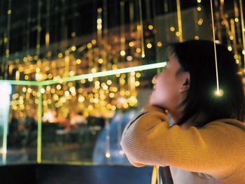 Young woman looking at illuminated christmas lights