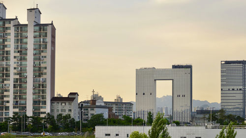 Buildings in city against sky during sunset