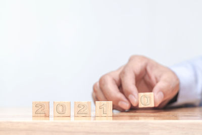 Human hand on wooden table against white background