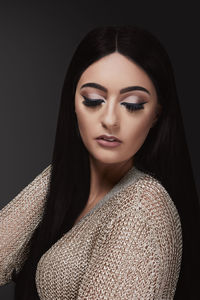 Beautiful woman wearing make-up against black background