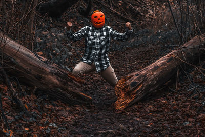 Full length of man with arms raised in forest