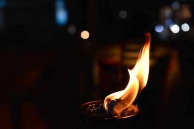 Close-up of lit candle in the dark