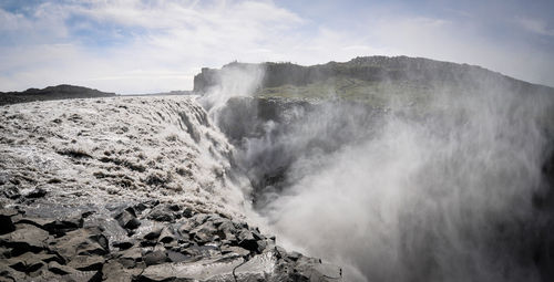 Scenic view of waterfall against sky