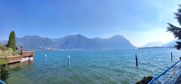 Scenic view of sea and mountains against blue sky