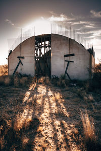 Abandoned factory on field against sky