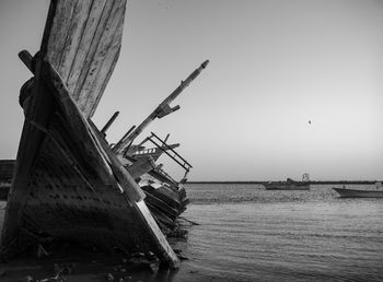 Abandoned ship in sea against clear sky