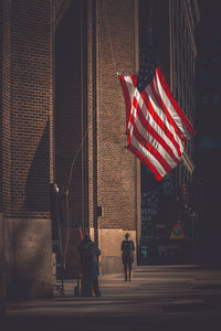 Rear view of people walking on street at night