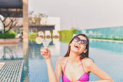 Young woman on inflatable ring in swimming pool