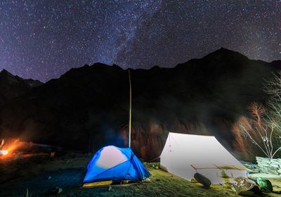 View of tent against mountain range at night