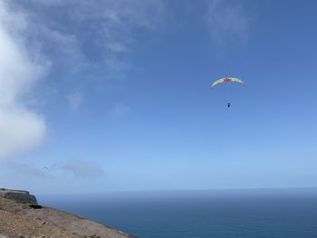 People paragliding over sea against sky