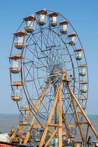 Low angle view of ferris wheel against clear sky