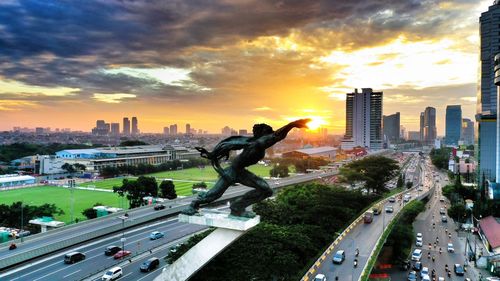 Aerial view of city against sky during sunset