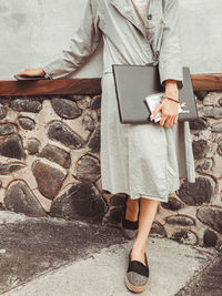 Low section of woman standing on mobile phone