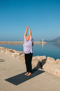 Rear view of woman standing at beach