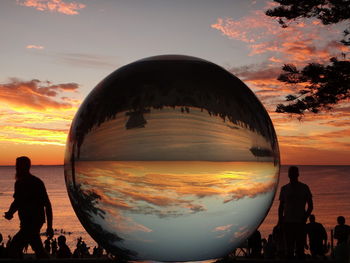 Man photographing at beach during sunset