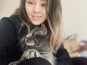 Portrait of smiling young woman with cat