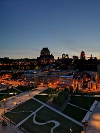 High angle view of illuminated buildings against sky at dusk