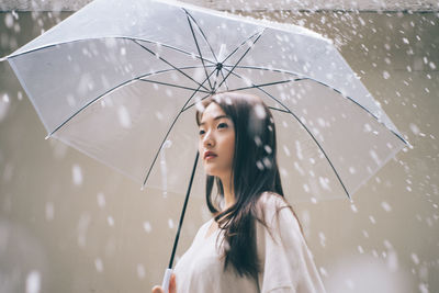 Young woman with umbrella looking away