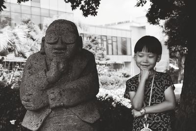 Smiling cute boy standing by statue