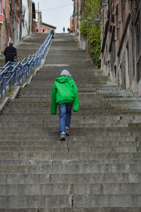 Rear view of man walking on staircase in liege 