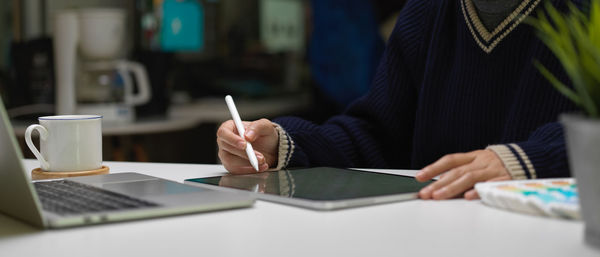 Midsection of woman working at desk