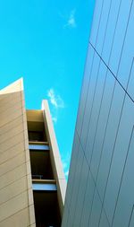 Low angle view of skyscraper against blue sky