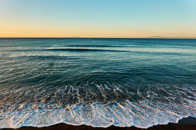 Scenic view of sea against clear sky during sunrise