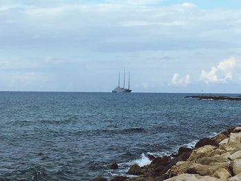 Sailboat sailing on sea against sky