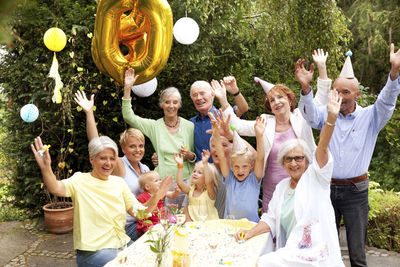 Extended family and friends having birthday party in garden